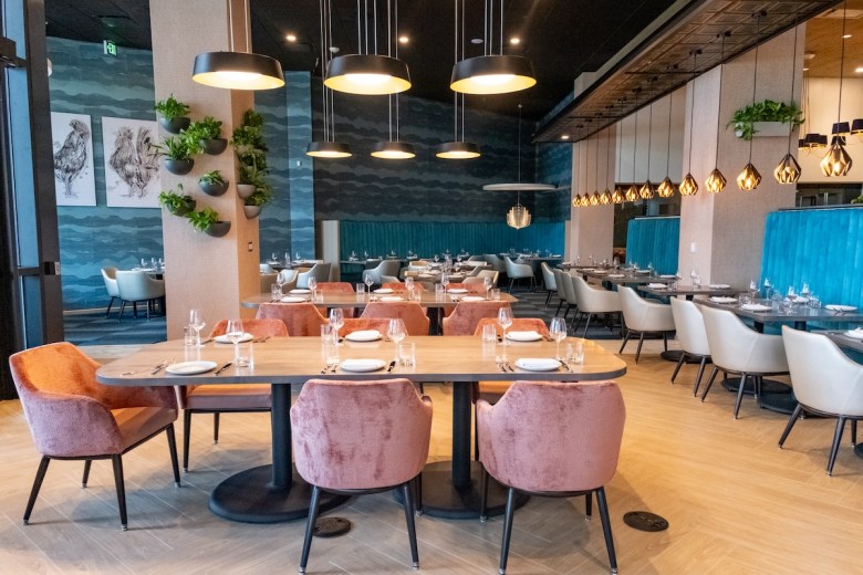 The interior of Hen Quarter Prime has bronze lights and light-colored wood furnishings with aqua backgrounds and accents. The new restaurant is located in the Southwest Waterfront area of D.C. near Audi Field. (Ja’Mon Jackson/The Washington Informer)
