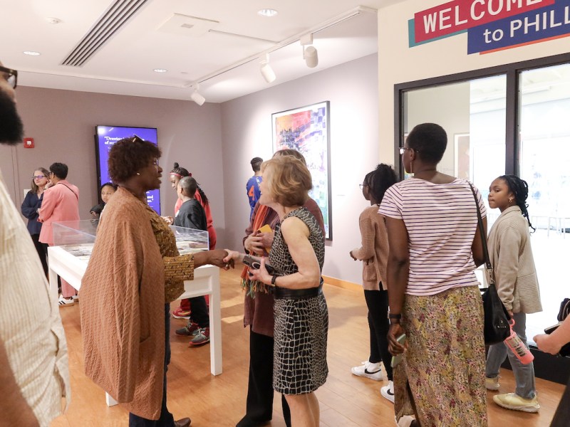 A vibrant gathering of art enthusiasts engaged in conversation and connection at the opening reception of an exhibition, their interactions as colorful and varied as the art that surrounds them. (Courtesy of Michael Anthony/@Mike.ant)