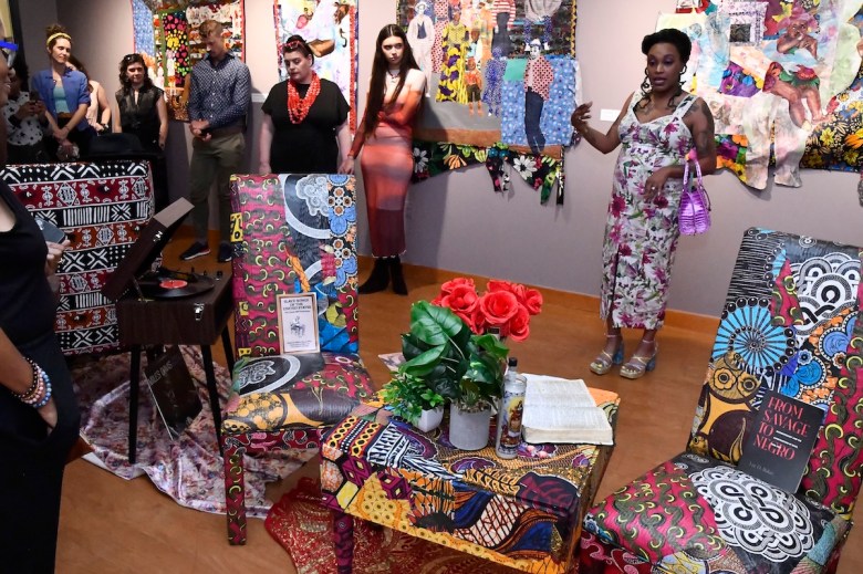 (In white print dress) Zsudayka Nzinga, a multidisciplinary artist, curator, and educator, discusses her collage “Home Coming / Home Going” currently on view at the Phillips at THEARC as a part of The Phillips Collection exhibition “Multiplicity: Blackness in Contemporary American Collage.” (Robert R. Roberts/The Washington Informer)